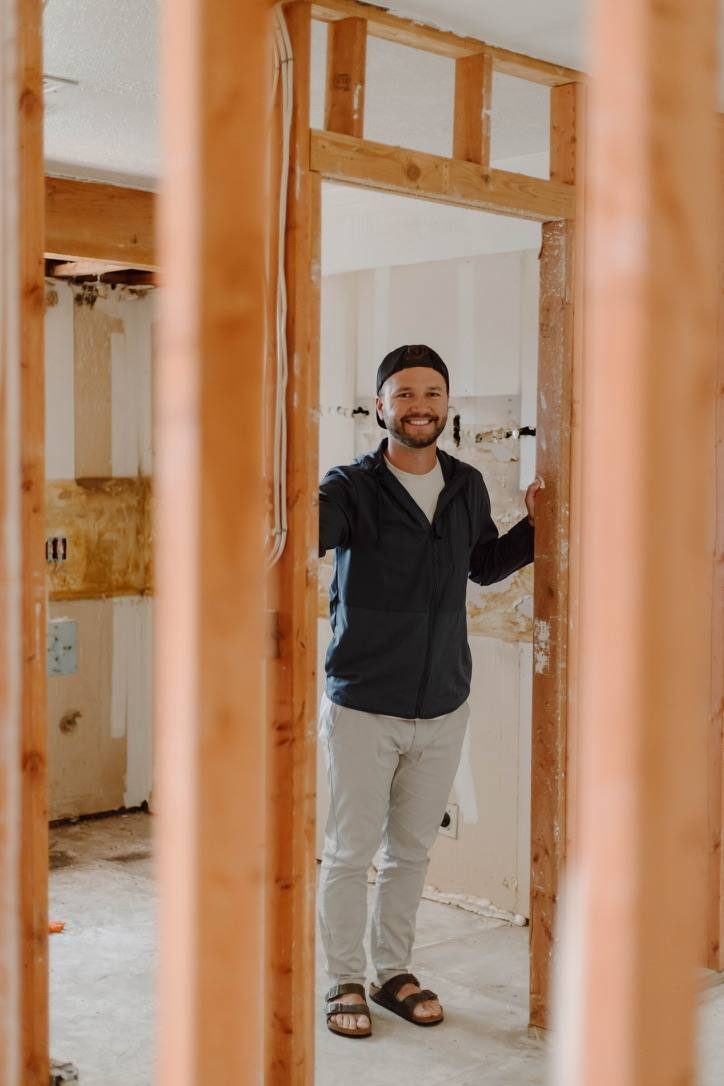 Kevin King standing in a gutted Tulsa flip framed by exposed wall studs during renovation